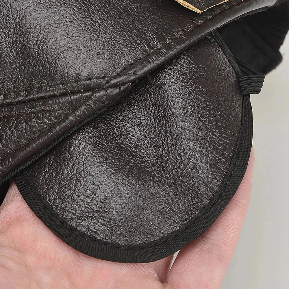 Close-up of a black leather bag held in a hand with a blurred background