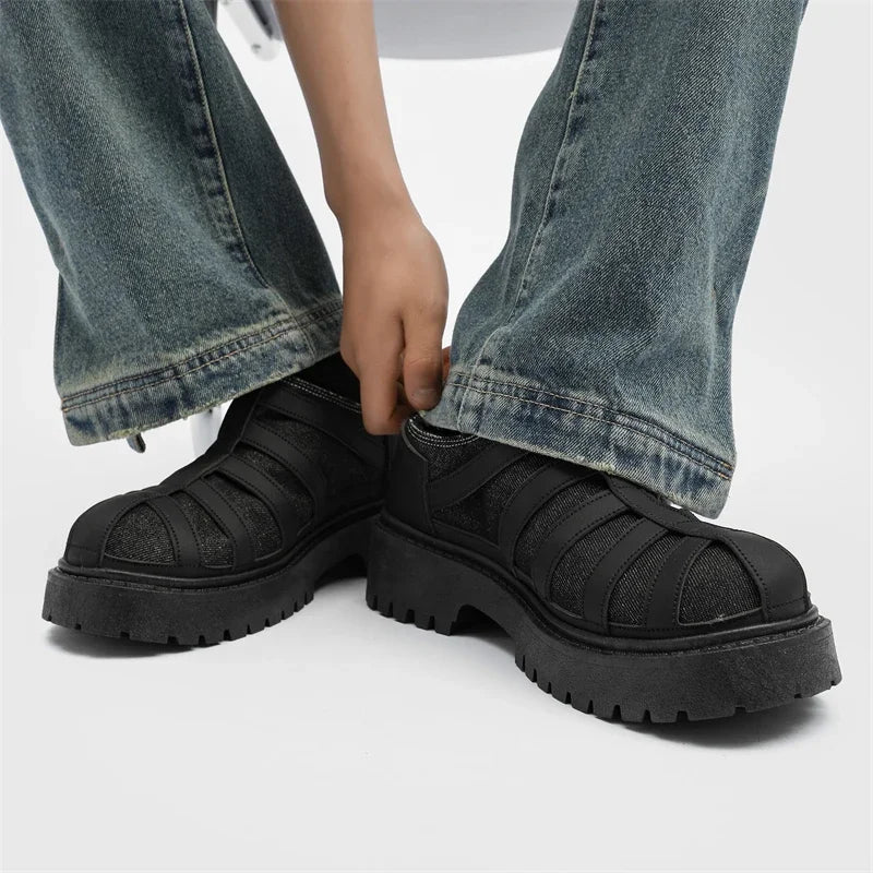 VOIDWEAR SIGNAL_VANISH_12 ☰ men’s split leather casual shoes with stitched upper, rubber sole, and ritual-inspired minimalist design. Person wearing black platform sandals with thick soles on a white background