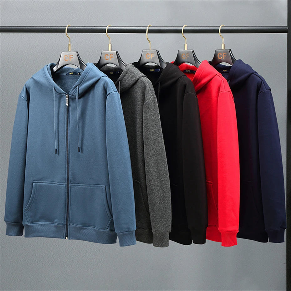 Five hoodies in blue, gray, black, red, and navy hanging on a rack against a gray background.OIDWEAR SHADOW_SYSTEM_07 ☰ full-zip hoodie shown worn in a concrete alleyway in winter, highlighting the oversized fit and fleece material.