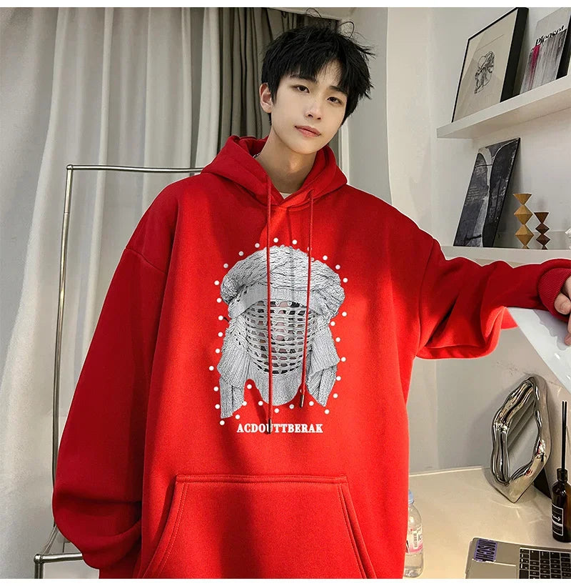 VOIDWEAR VDR_SHDW_07 oversized goth hoodie with masked figure graphic, in black, styled in urban streetwear fit. Person wearing a red hoodie with a graphic design and text, standing indoors.