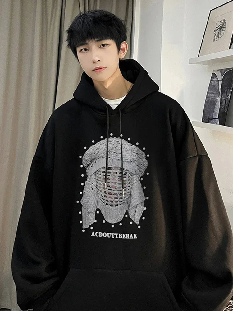 VOIDWEAR VDR_SHDW_07 oversized goth hoodie with masked figure graphic, in black, styled in urban streetwear fit. Person wearing a black hoodie with a graphic design in a room.