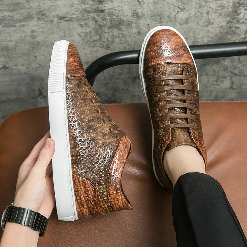 Brown patterned sneakers with white soles worn by a person sitting on a brown chair.