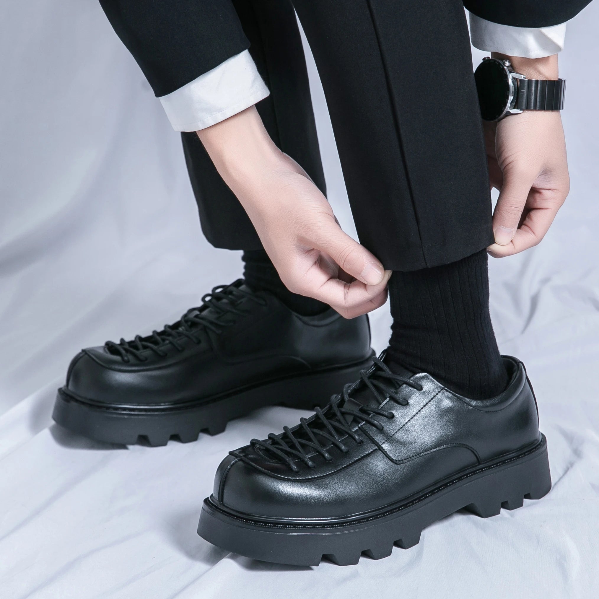 VOIDWEAR SIGNAL_VANISH_11 ☰ split leather platform streetwear shoes with lace-up closure and shadow-coded design, optimized for spring and autumn. Person wearing black leather shoes with thick soles on a light gray background