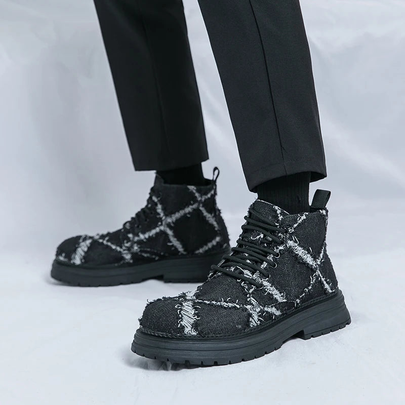 Black and white checkered boots worn with black pants on a light gray background. VOIDWEAR SIGNAL_VANISH_07 ☰ high-top split leather loafers with slip-on design, breathable build, and shadow-motion streetwear aesthetic