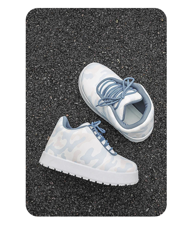 White sneakers with blue accents on a black textured surface