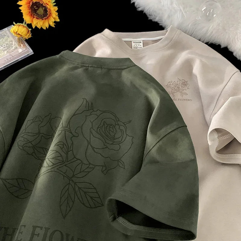 VOIDWEAR VDR_FLO_09 oversized goth floral graphic t-shirt in apricot, styled for streetwear layering. Two shirts, one green with a rose design and one beige with text, on a dark surface.