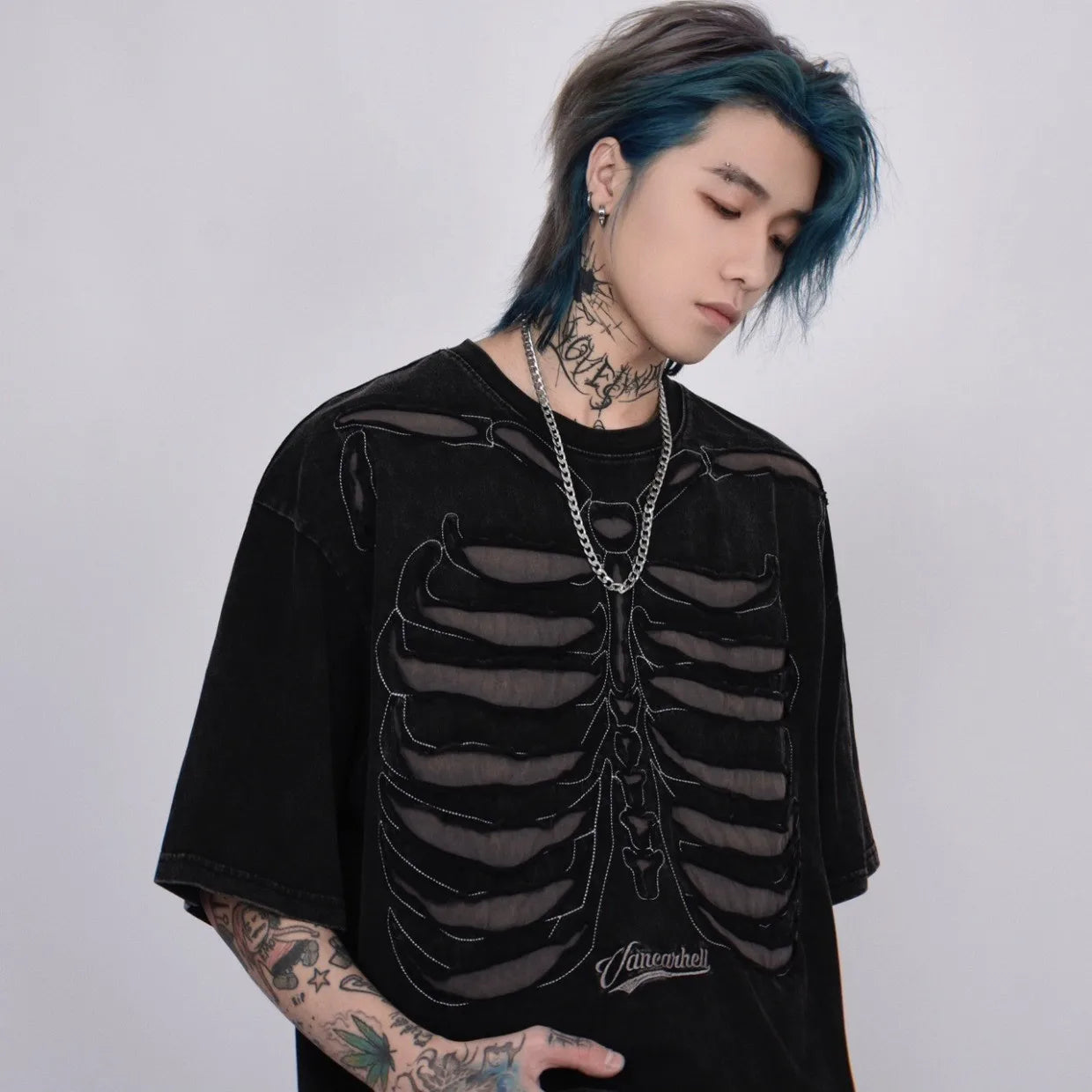 VOIDWEAR VDR_VANISH_05 ripped skeleton tee washed vintage cotton men’s summer streetwear USA. Person wearing a black skeleton design shirt with tattoos and blue hair.
