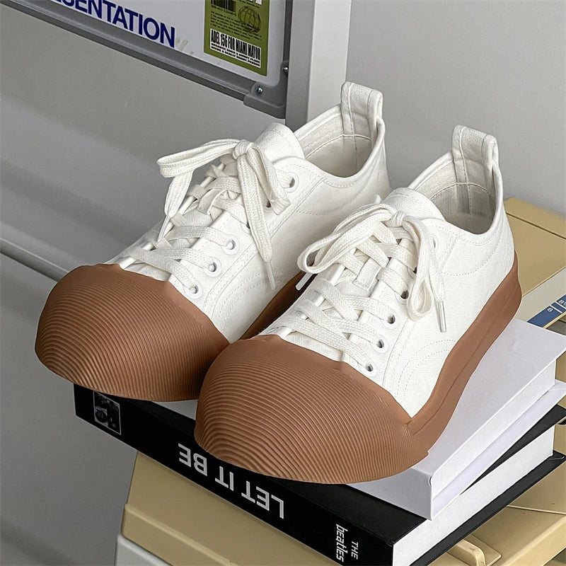 White sneakers with brown soles on a shelf with books