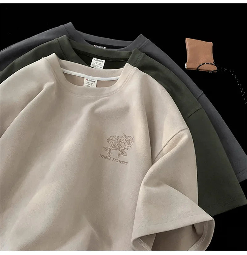 VOIDWEAR VDR_FLO_09 oversized goth floral graphic t-shirt in apricot, styled for streetwear layering. Beige sweatshirt with floral embroidery and text, displayed with black and gray sweaters on a dark background.
