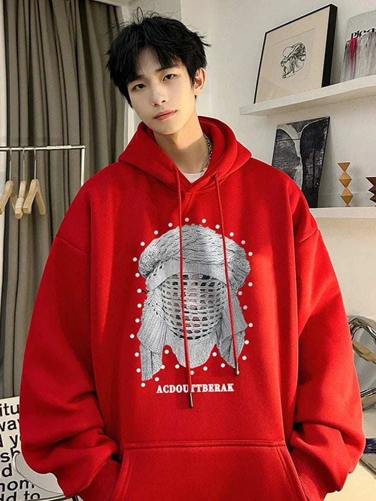 VOIDWEAR VDR_SHDW_07 oversized goth hoodie with masked figure graphic, in black, styled in urban streetwear fit. Person wearing a red hoodie with a graphic design indoors