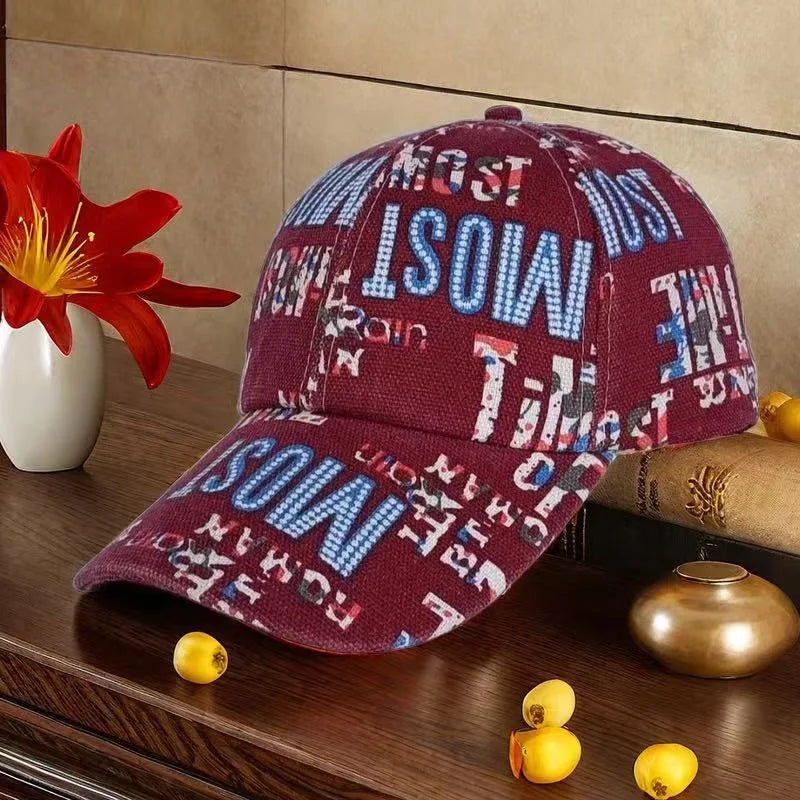 Maroon cap with colorful text on a wooden surface with decorative items