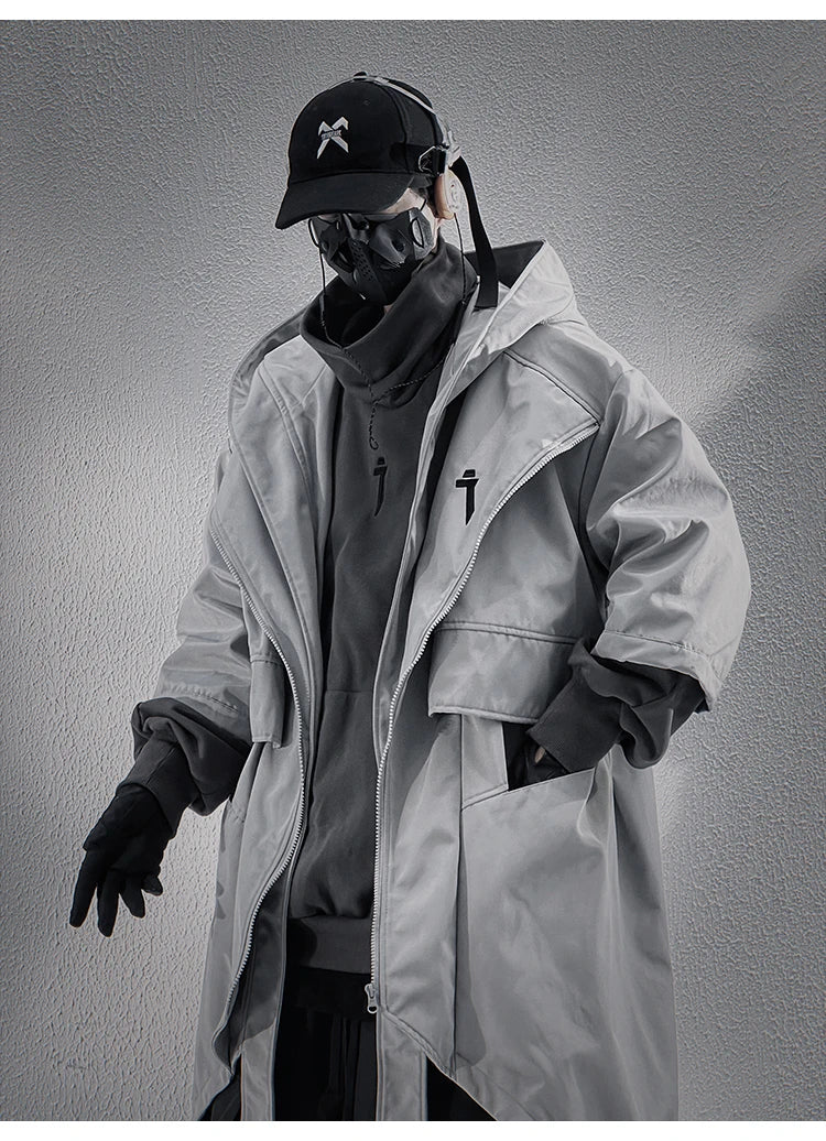 A male model in the Voidwear SIGNAL_VANISH_05 ☰, a minimalist and conceptual mid-sleeved hooded trench coat designed for stylish urban wear in the US and EU.