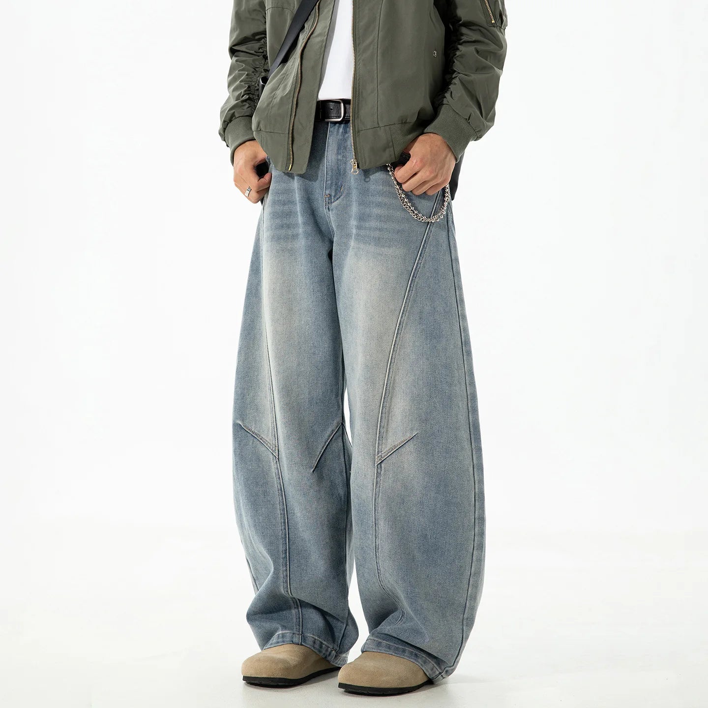 VOIDWEAR VDR_VANISH_SPLIT ☰ curved split distressed jeans, light wash, loose streetwear silhouette, coded glyph tab. Person wearing a green jacket and blue jeans on a white background
