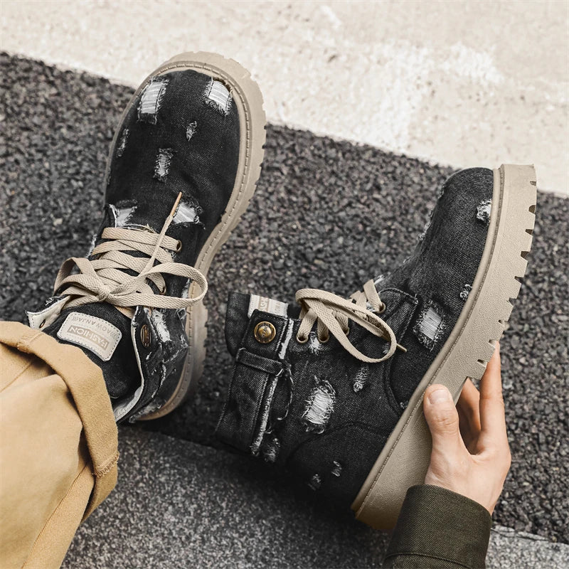 VOIDWEAR SIGNAL_VANISH_12 ☰ men’s denim ankle boots with lace-up closure, EVA insole, rubber outsole, ritual-inspired streetwear design. Black distressed boots with beige soles worn by a person on a textured surface.