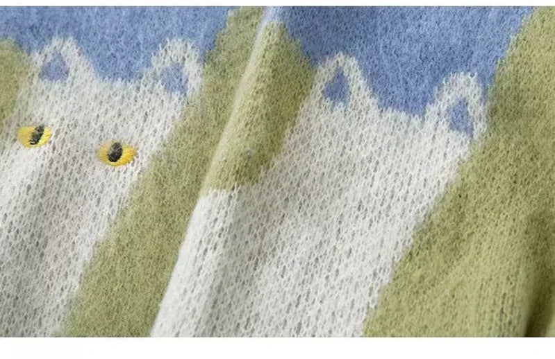 Close-up of a knitted fabric with green, white, and blue pattern