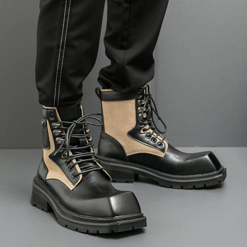 Black and beige leather boots worn with black pants on a gray background