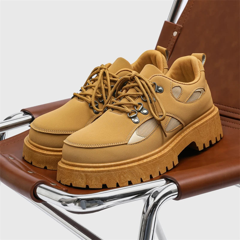 VOIDWEAR SIGNAL_VANISH_10 ☰ ankle-height PU leather boots with platform rubber outsole, mesh lining, and minimalist vanish design for spring/autumn. Tan work boots on a brown chair with a white background