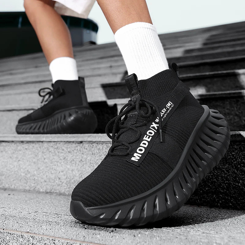 VOIDWEAR SIGNAL_VANISH_07 mesh sneakers, lightweight breathable techwear-inspired streetwear shoes with ankle wrap design. Black Modeox sneakers worn on a person's feet stepping onto stairs.