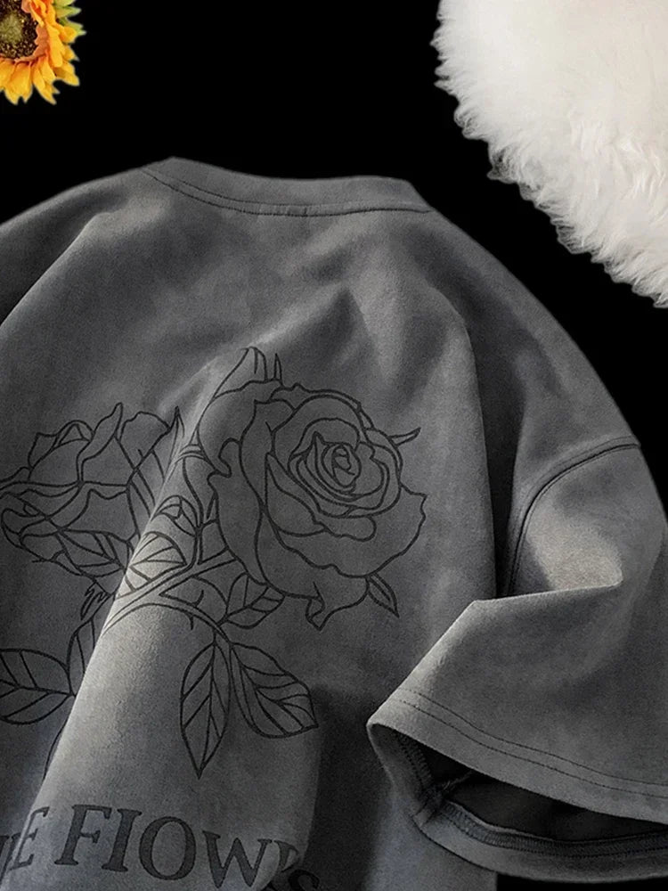 VOIDWEAR VDR_FLO_09 oversized goth floral graphic t-shirt in apricot, styled for streetwear layering. Gray sweatshirt with black rose design and 'FLOWS' text, sunflower and white fluffy object in background