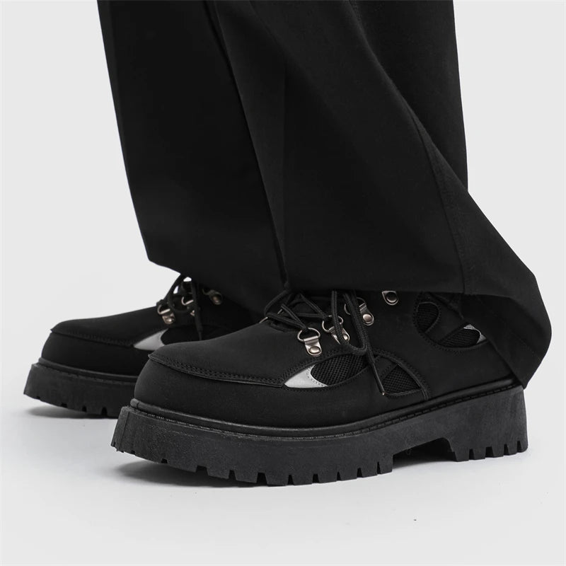 VOIDWEAR SIGNAL_VANISH_10 ☰ ankle-height PU leather boots with platform rubber outsole, mesh lining, and minimalist vanish design for spring/autumn. Black platform boots worn with black pants on a light gray background