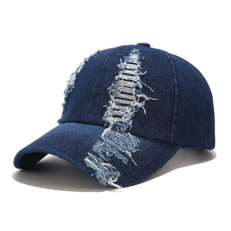 Vintage washed denim snapback by VOIDWEAR with distressed holes, ritual glyph detailing, and adjustable strap, designed for all-season streetwear. Denim cap with distressed design on a white background
