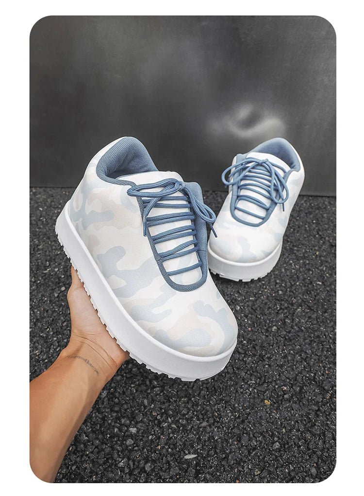 White sneakers with blue laces held by a hand on a dark surface. VOIDWEAR CODE_SYSTEM_07 ⚔️ chunky sneaker-style boots shown on a city street in winter, highlighting the microfiber leather upper and thick platform sole.