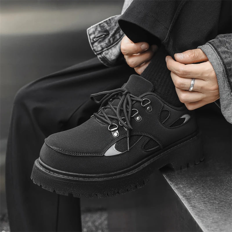 VOIDWEAR SIGNAL_VANISH_10 ☰ ankle-height PU leather boots with platform rubber outsole, mesh lining, and minimalist vanish design for spring/autumn. Person wearing black platform shoes with a blurred background