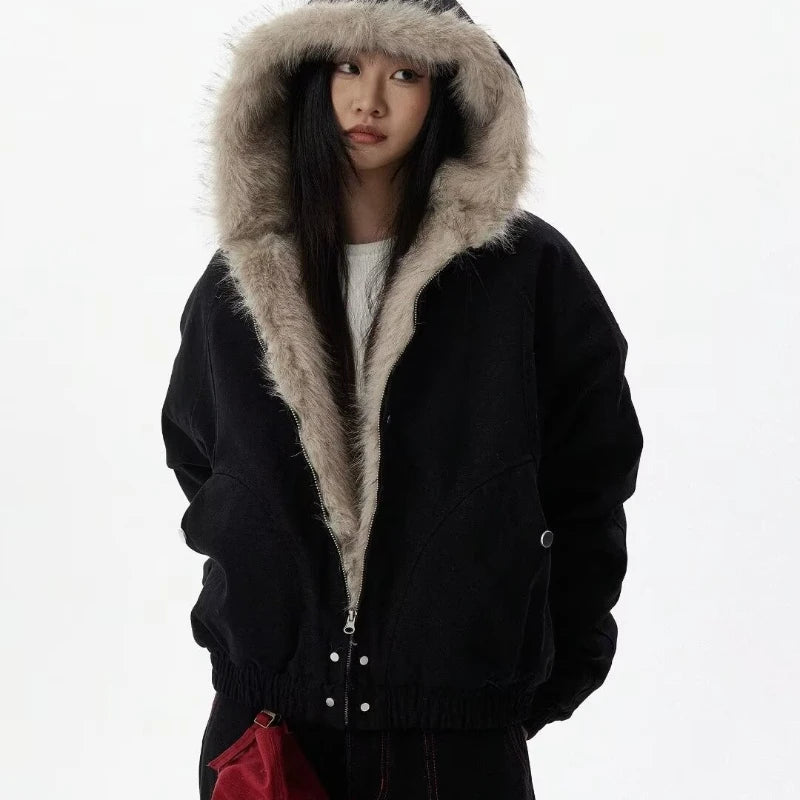VOIDWEAR™ VDR_25 — a unisex oversized plush hooded jacket. Person wearing a black coat with fur hood on a white background