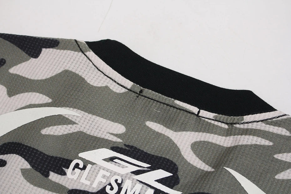 VOIDWEAR oversized camo tee with glyph and vanish-mode hood, 100% cotton, streetwear long sleeve. Camouflage-patterned product with a brand logo on a white background