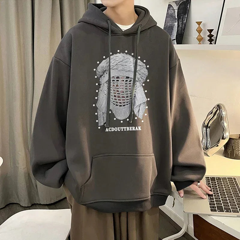 VOIDWEAR VDR_SHDW_07 oversized goth hoodie with masked figure graphic, in black, styled in urban streetwear fit. Person wearing a dark gray hoodie with a graphic design in an indoor setting.