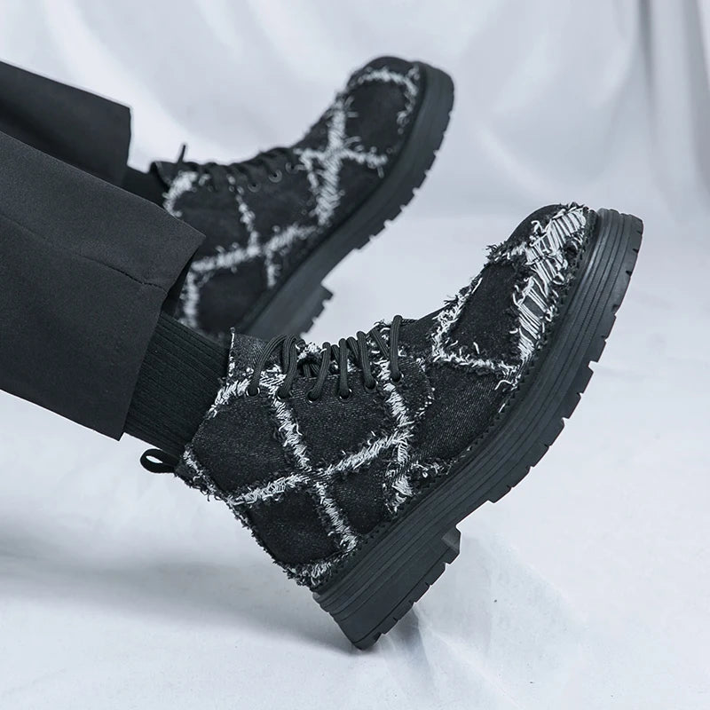 Black checkered boots worn with black pants on a light gray background. VOIDWEAR SIGNAL_VANISH_07 ☰ high-top split leather loafers with slip-on design, breathable build, and shadow-motion streetwear aesthetic