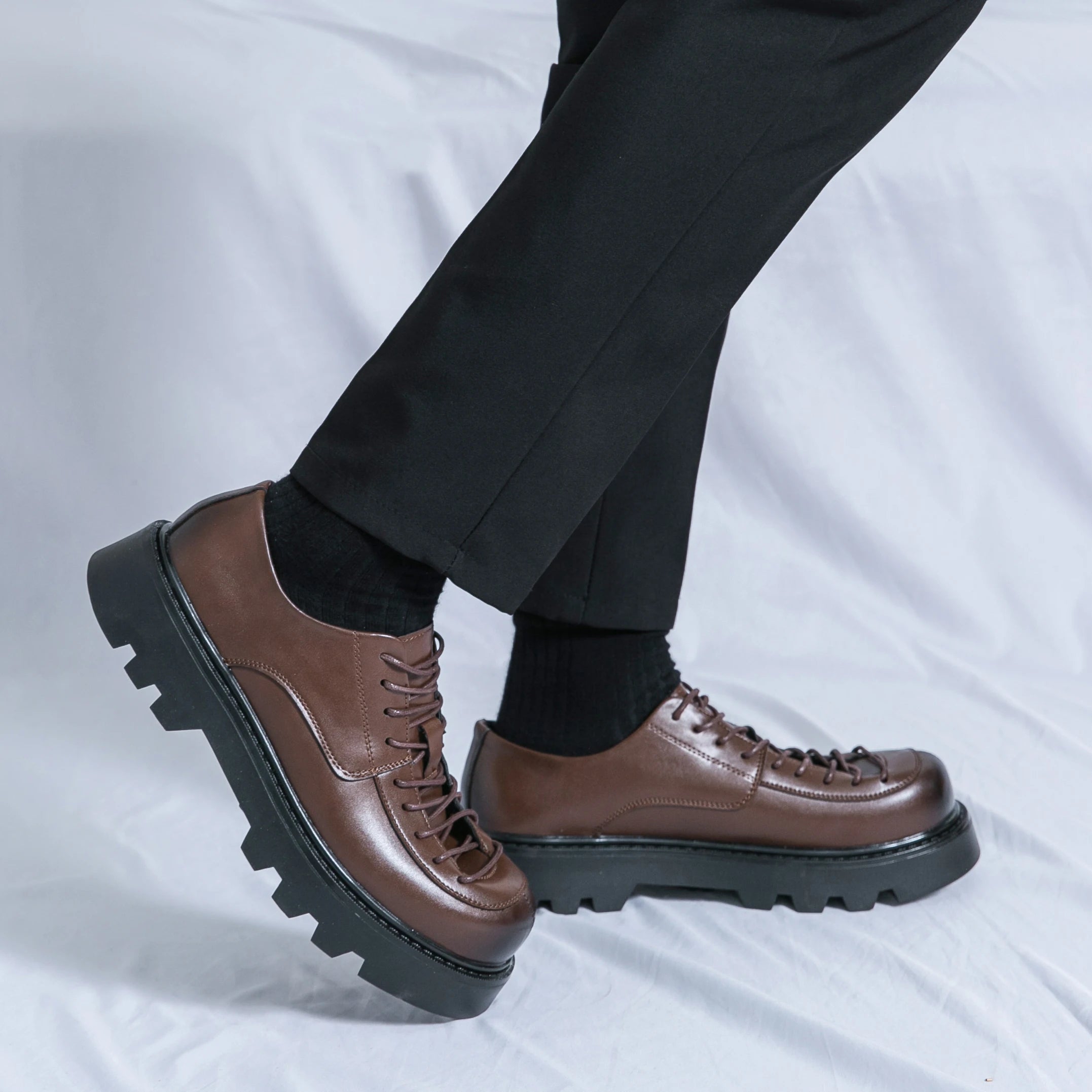 VOIDWEAR SIGNAL_VANISH_11 ☰ split leather platform streetwear shoes with lace-up closure and shadow-coded design, optimized for spring and autumn. Brown leather shoes worn with black pants on a light gray background