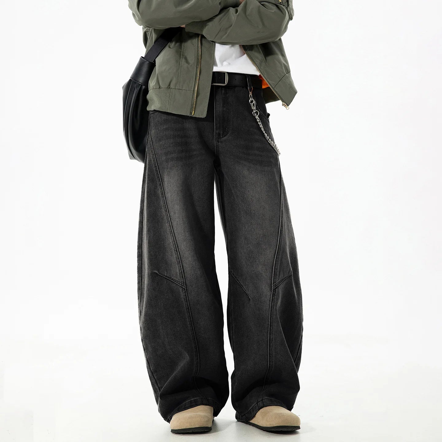 VOIDWEAR VDR_VANISH_SPLIT ☰ curved split distressed jeans, light wash, loose streetwear silhouette, coded glyph tab. Person wearing black wide-leg jeans with a green jacket on a white background