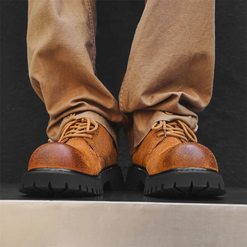 Men’s VOIDWEAR VDR_SIGNAL_03 derby shoes in black leather with thick rubber sole, slip-on design, and ritual-inspired streetwear aesthetic. Brown leather boots with thick soles worn with matching brown pants on a dark background